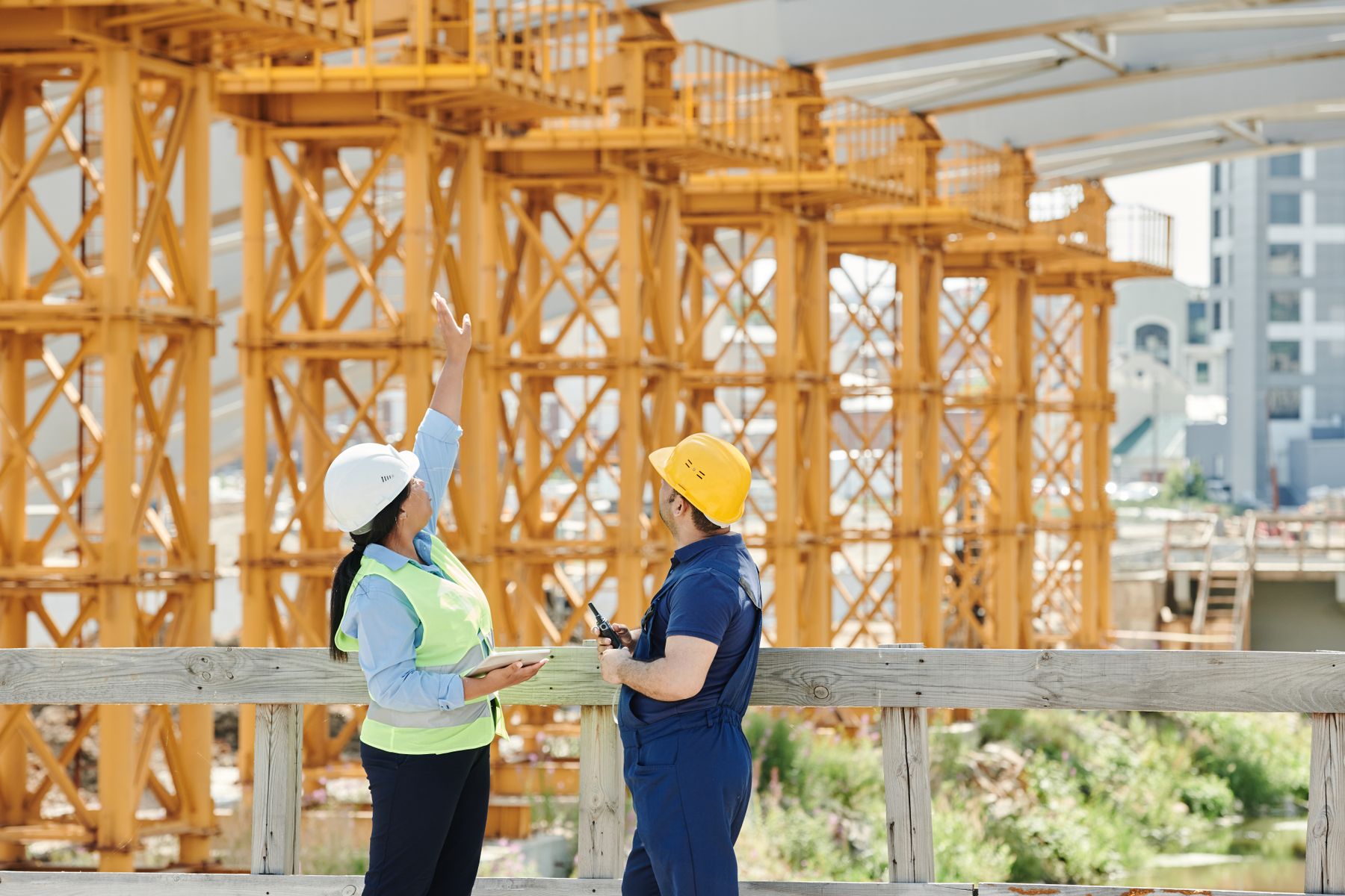 Site supervisors reviewing project progress with a tablet on the jobsite